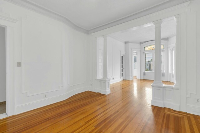 123 Shippen St, Weehawken, NJ 07086 - spare room with a decorative wall, light wood finished floors, ornamental molding, and ornate columns