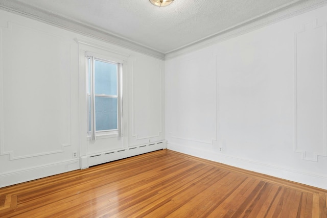 123 Shippen St, Weehawken, NJ 07086 - unfurnished room featuring baseboard heating, wood-type flooring, a textured ceiling, and crown molding