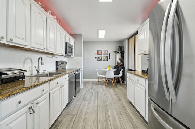 200 Winston Dr Unit 803, Cliffside Park, NJ 07010 - kitchen with stainless steel appliances, white cabinets, decorative backsplash, and light wood-style flooring