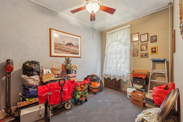 rec room with crown molding, radiator heating unit, a ceiling fan, and carpet floors