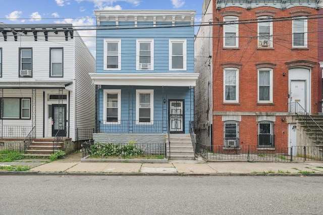 81 Atlantic St, Jersey City, NJ 07304 - italianate home featuring a porch, a fenced front yard, and brick siding