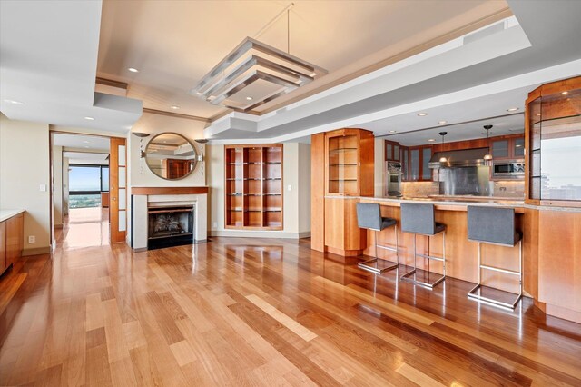 200 Old Palisade Rd Ph 4/5, Fort Lee, NJ 07024 - kitchen featuring appliances with stainless steel finishes, glass insert cabinets, light wood finished floors, range hood, and a kitchen breakfast bar