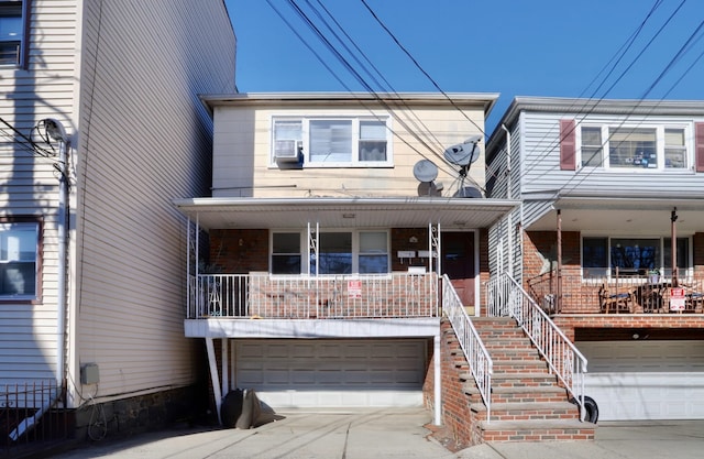 multi unit property featuring brick siding, a porch, and concrete driveway