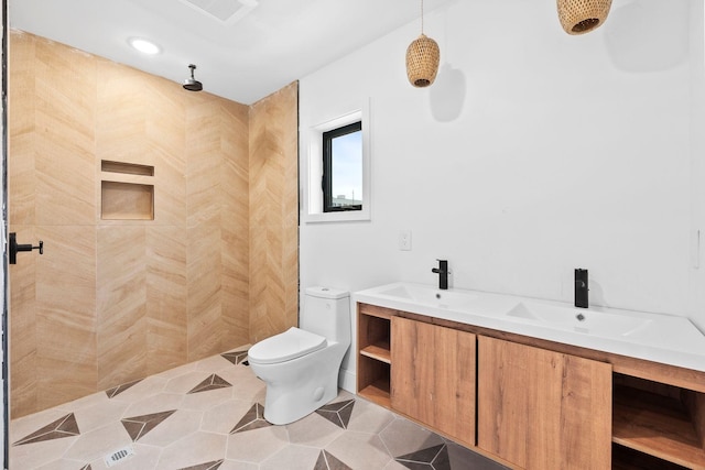 bathroom featuring tiled shower, vanity, toilet, and tile patterned flooring