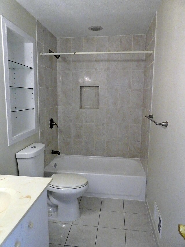 full bathroom featuring toilet, vanity, tiled shower / bath combo, and tile patterned floors