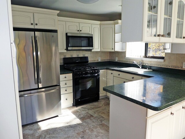 kitchen featuring white cabinets, kitchen peninsula, stainless steel appliances, and sink