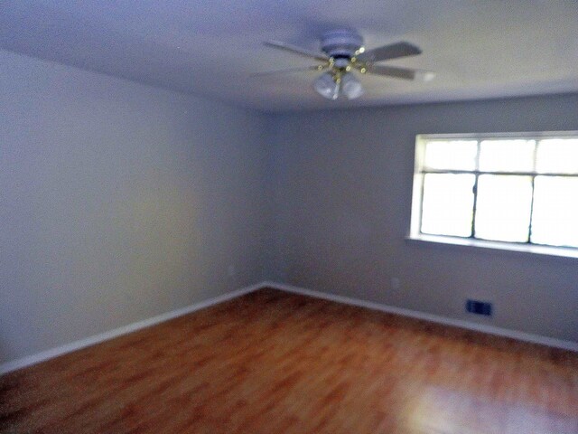 unfurnished room with ceiling fan and wood-type flooring