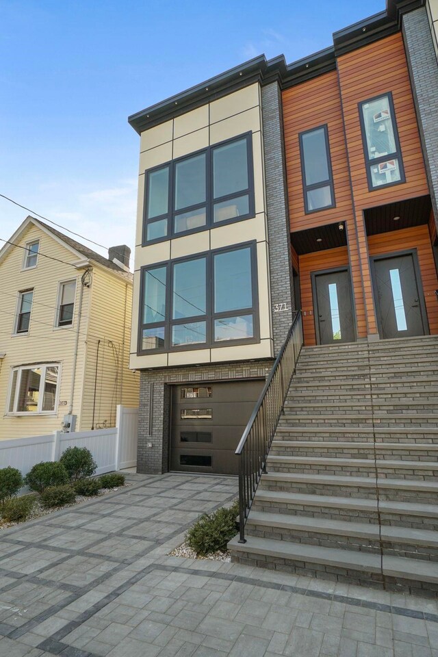 371 New York Ave Unit 2, Jersey City, NJ 07307 - view of front of house with concrete driveway, a garage, and stairs