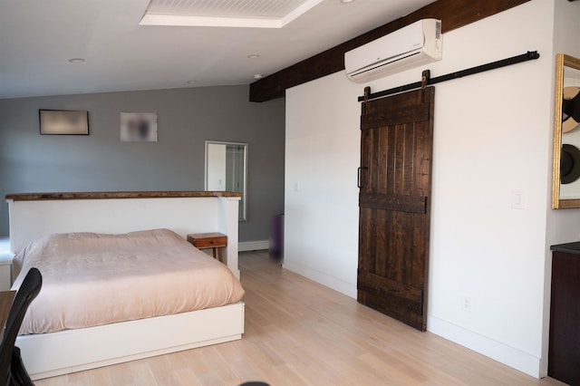 bedroom with a barn door, a wall mounted AC, light wood-type flooring, and vaulted ceiling