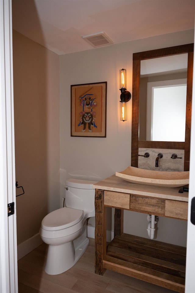 bathroom featuring hardwood / wood-style flooring and toilet