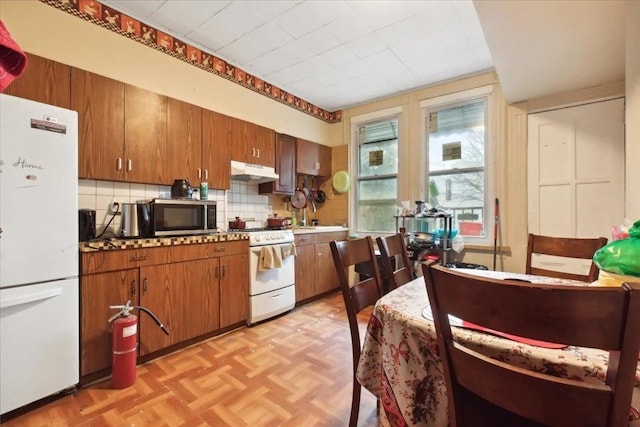 kitchen featuring tasteful backsplash, white appliances, and light parquet floors