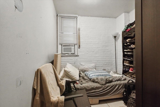 interior space featuring cooling unit, light tile patterned flooring, and brick wall