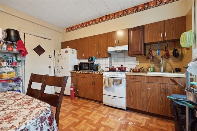 kitchen with decorative backsplash, sink, white appliances, and light parquet floors