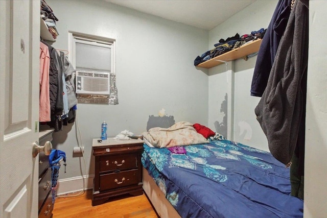 bedroom with light hardwood / wood-style floors and cooling unit