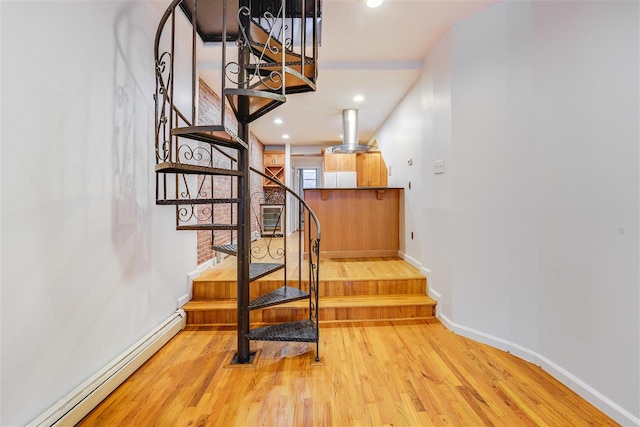 staircase with hardwood / wood-style flooring and a baseboard radiator