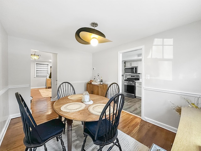 dining space with hardwood / wood-style floors