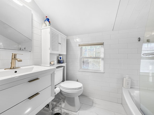 bathroom featuring vanity, tile walls, and toilet