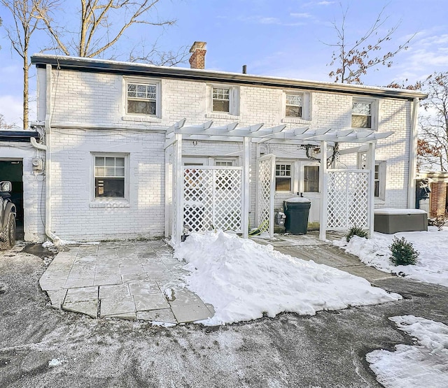 snow covered property featuring a pergola