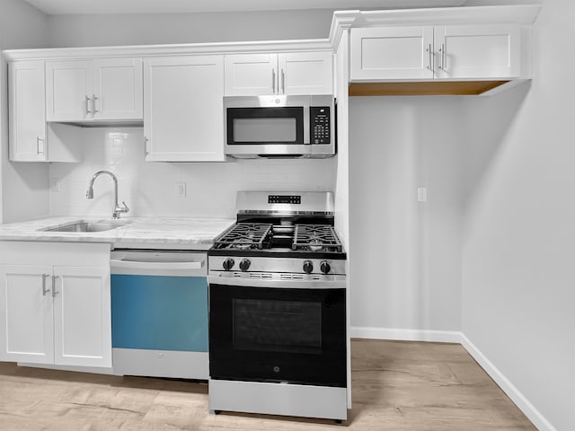 kitchen featuring white cabinets, appliances with stainless steel finishes, backsplash, and sink