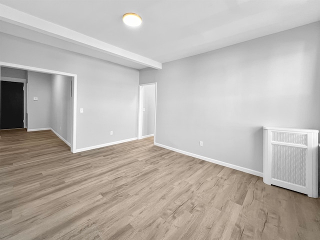 spare room featuring light hardwood / wood-style floors and heating unit