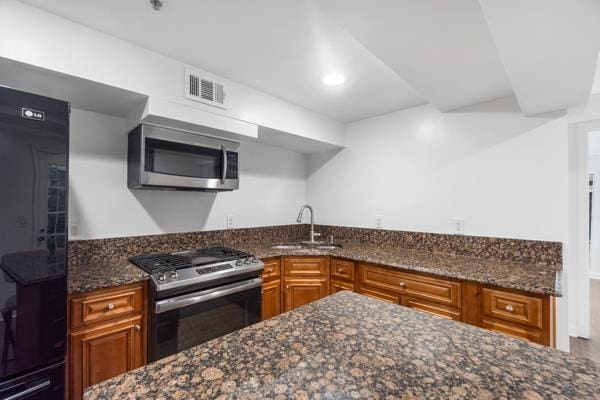 2608 Kennedy Blvd Unit 1, Union City, NJ 07087 - kitchen featuring appliances with stainless steel finishes, brown cabinets, dark stone counters, and recessed lighting