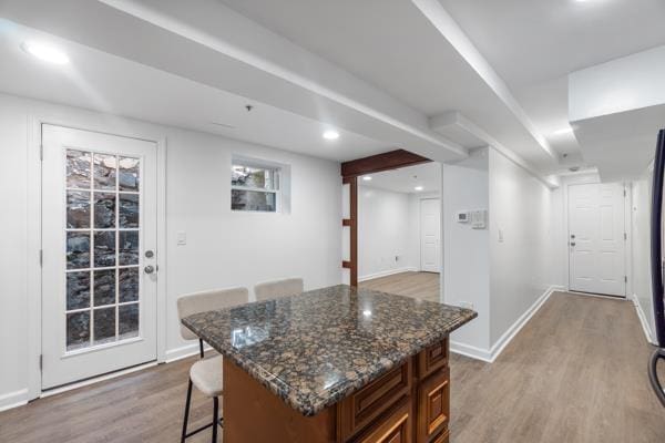 2608 Kennedy Blvd Unit 1, Union City, NJ 07087 - kitchen with light wood-style flooring, a breakfast bar area, dark stone countertops, a kitchen island, and recessed lighting