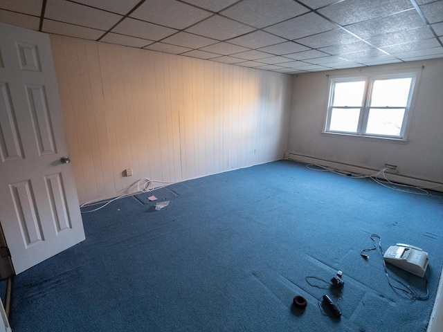 62 Hancock Ave, Jersey City, NJ 07307 - carpeted spare room featuring a drop ceiling, wooden walls, and a baseboard heating unit