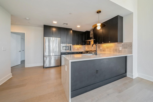 202 Merseles St Unit 503, Jersey City, NJ 07302 - kitchen with appliances with stainless steel finishes, light countertops, tasteful backsplash, a peninsula, and under cabinet range hood