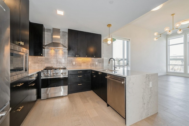 202 Merseles St Unit 503, Jersey City, NJ 07302 - kitchen featuring appliances with stainless steel finishes, wall chimney exhaust hood, dark cabinets, and light wood-style floors
