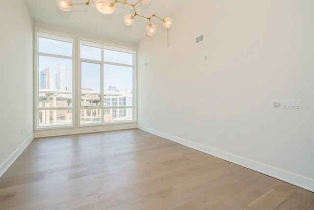 202 Merseles St Unit 503, Jersey City, NJ 07302 - empty room with a view of city, a chandelier, and light wood finished floors