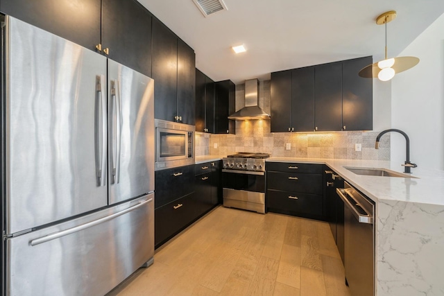 202 Merseles St Unit 503, Jersey City, NJ 07302 - kitchen featuring appliances with stainless steel finishes, wall chimney exhaust hood, dark cabinetry, and light stone counters