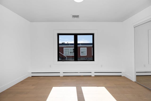 829 Boulevard, Weehawken, NJ 07086 - unfurnished room with light wood-type flooring, visible vents, a baseboard heating unit, and baseboards