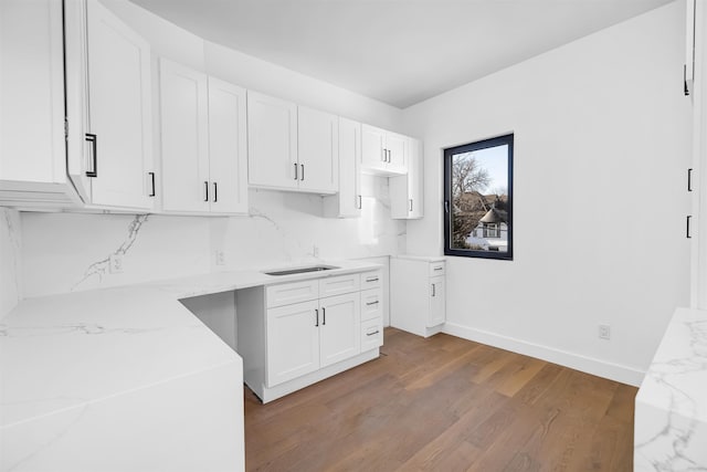829 Boulevard, Weehawken, NJ 07086 - kitchen featuring tasteful backsplash, baseboards, white cabinets, wood finished floors, and light stone countertops