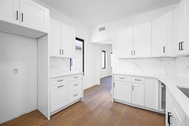 829 Boulevard, Weehawken, NJ 07086 - kitchen with backsplash, visible vents, white cabinets, and dark wood-style flooring