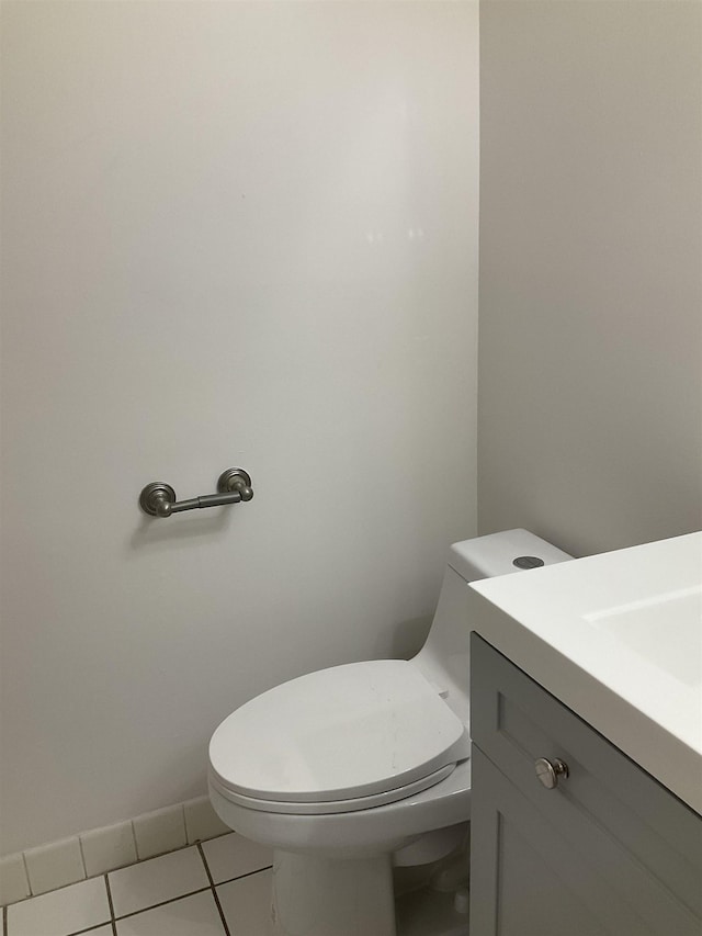 bathroom with toilet, vanity, and tile patterned floors