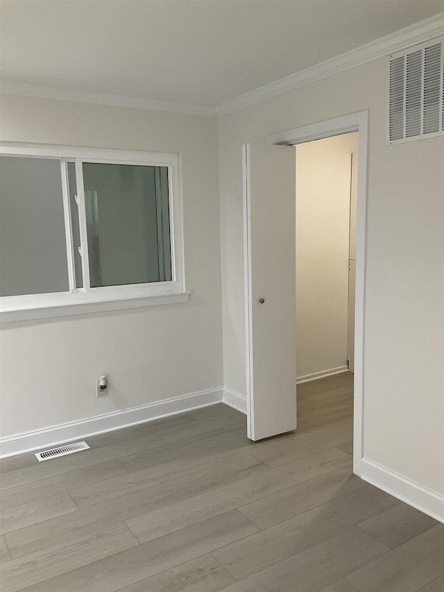 unfurnished room with crown molding and hardwood / wood-style flooring