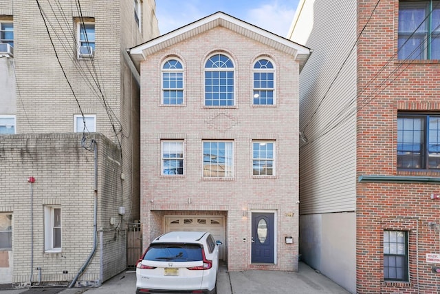 view of front facade featuring a garage, brick siding, and driveway