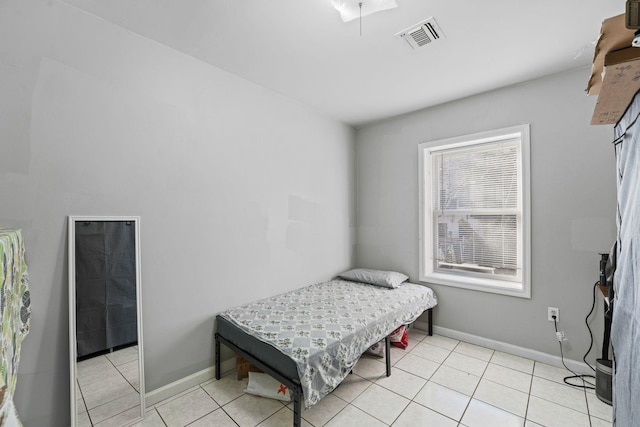 bedroom featuring visible vents, baseboards, and light tile patterned floors