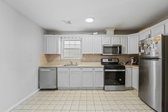 kitchen featuring appliances with stainless steel finishes, light countertops, visible vents, and white cabinetry