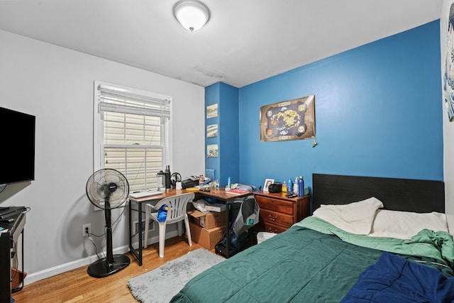 bedroom featuring baseboards and wood finished floors