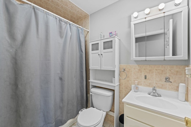 bathroom featuring toilet, a shower with shower curtain, tile walls, and vanity