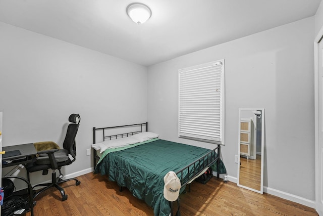 bedroom featuring wood finished floors and baseboards