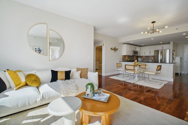 living room featuring a chandelier, dark wood-type flooring, baseboards, and recessed lighting