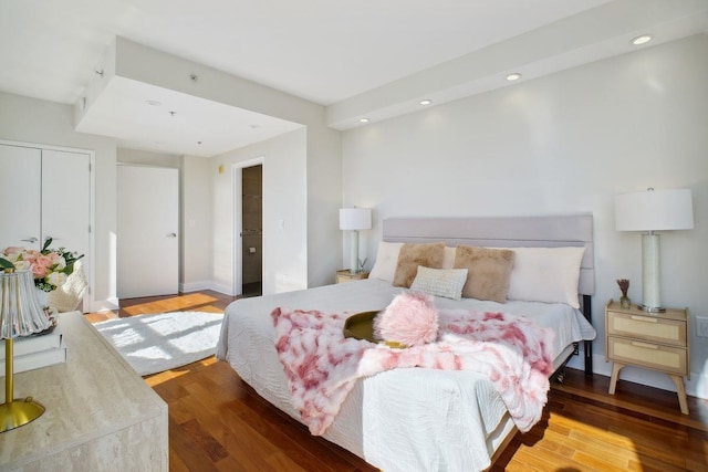 bedroom with a closet, wood finished floors, and recessed lighting