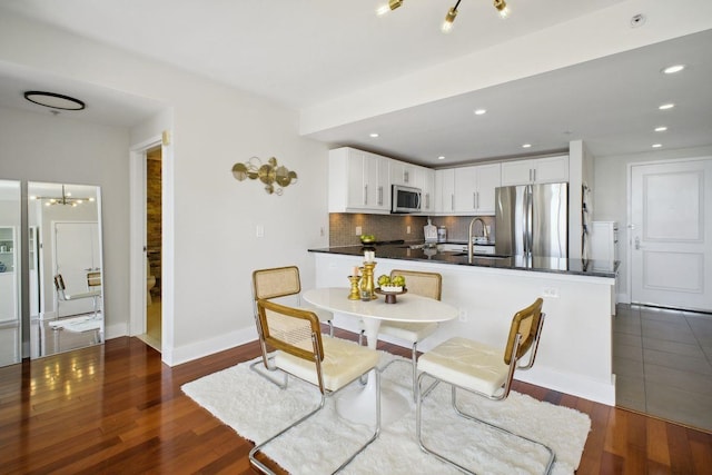 dining room featuring a chandelier, recessed lighting, dark wood finished floors, and baseboards