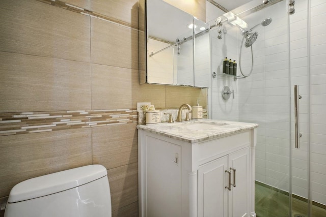 full bath with a stall shower, toilet, tile walls, and vanity