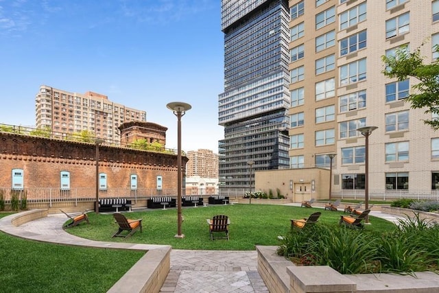 view of community featuring a view of city and a yard