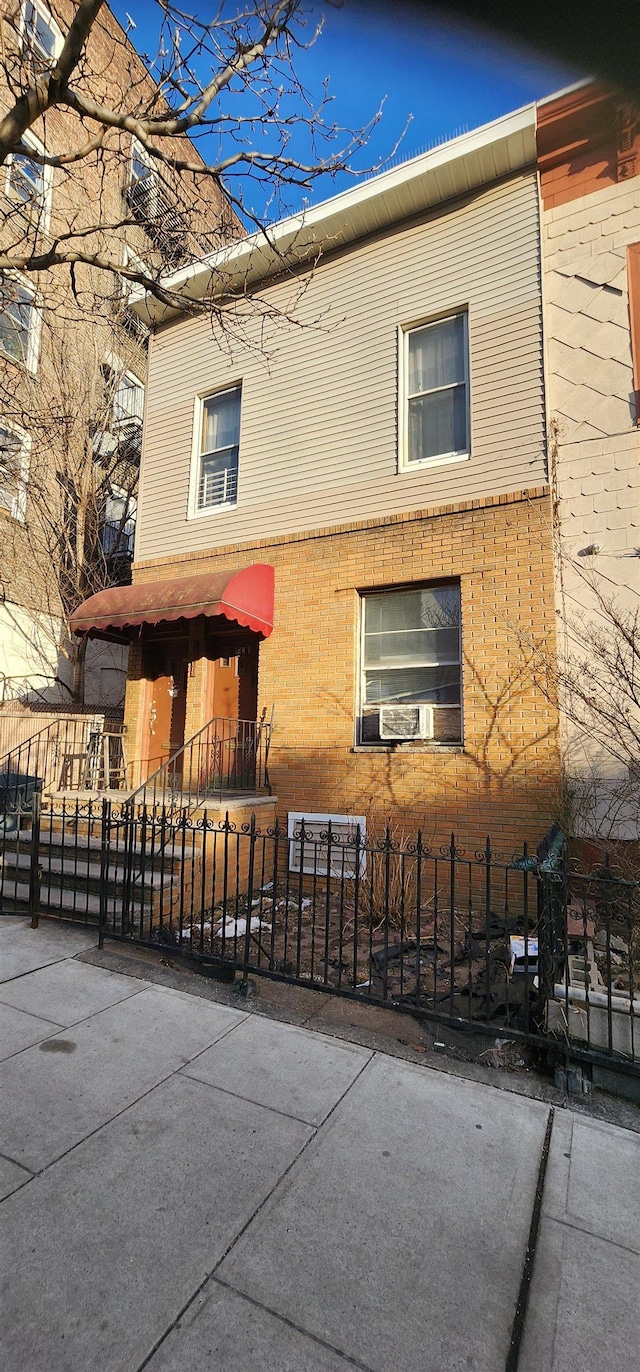 view of property exterior with brick siding and a fenced front yard