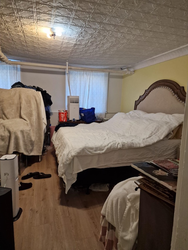 bedroom featuring an ornate ceiling and wood finished floors