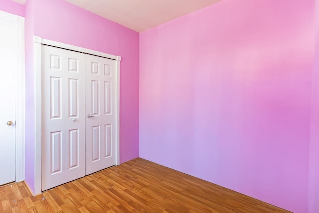 unfurnished bedroom with light hardwood / wood-style floors and a closet